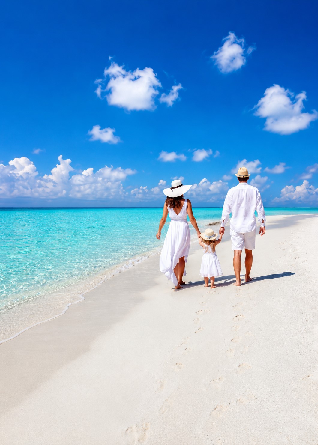 Dos viajeros con una niña paseando por una playa paradisíaca en calma